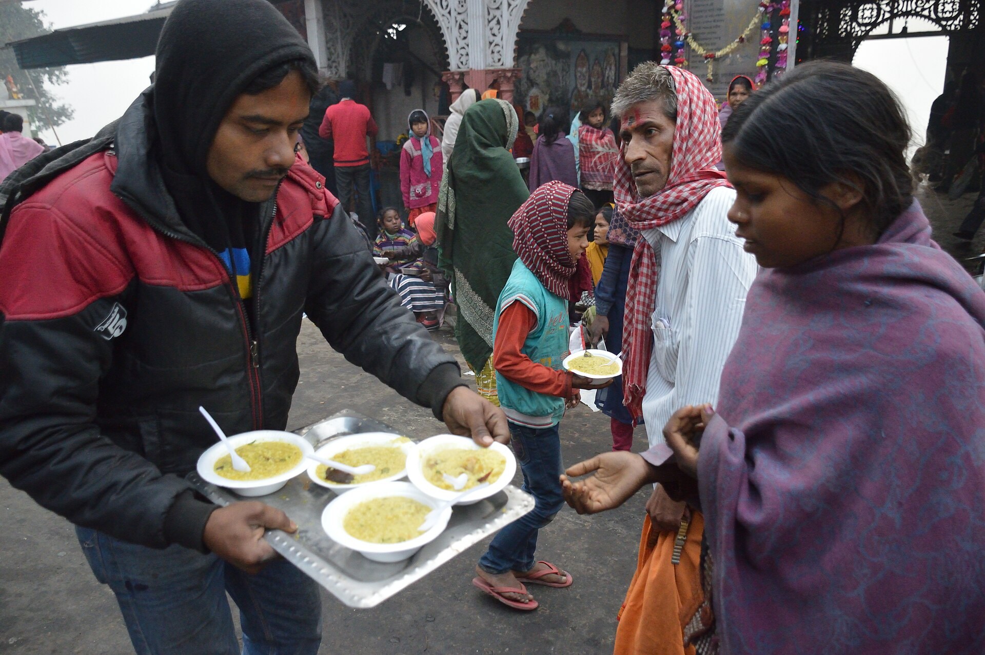 Volunteers serving hot meals to families at a community food drive